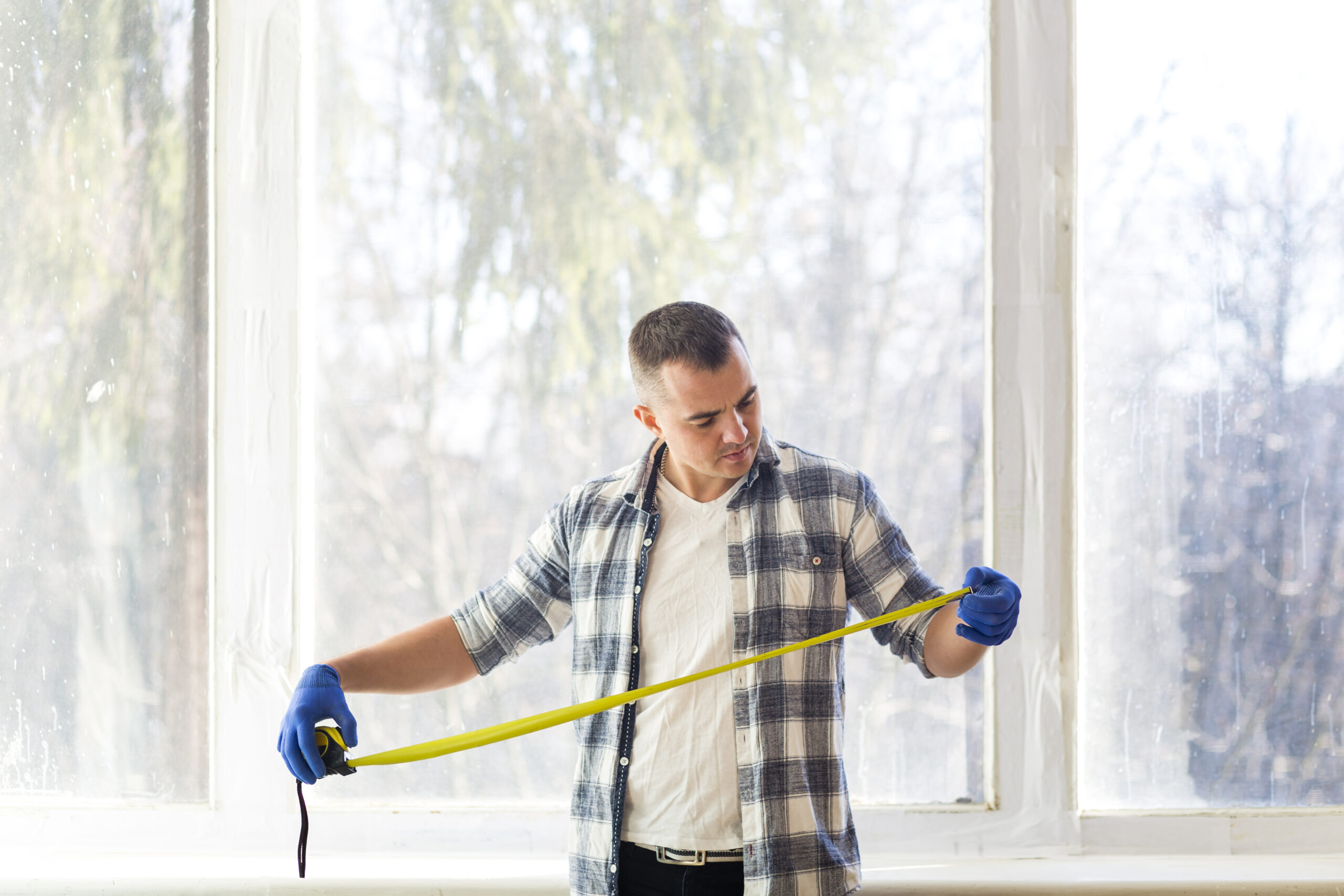 medium-shot-man-looking-tape-measure
